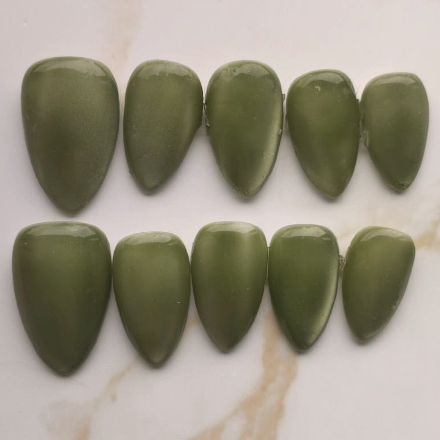 Gem Olive press-on nagels — flat lay productfoto, signature wide almond